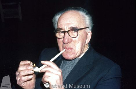 Tom Henderson smokes a pipe from the Kennemerland Photo Shetland Museum and Archives