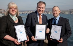 SSMO manager Jenny Mowat, Scottish fisheries secretary Richard Lochhead and NAFC head of science Martin Robinson receiving MSC accreditation for Shetland's king scallop fishery. Photo SN