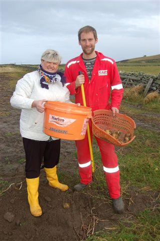 Presenter Eunice Henderson selecting tatties with Leighton Flaws for BBC Radio Shetland's late show Shetland's Larder. Photo Jane Moncrieff