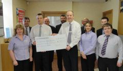 Lerwick Clydesdale Bank manager Rod MacLeod hands the large cheque over to Jim Livitt of the memorial committee. Back (from left): Robbie Leask, Alistair Carnie, Steve Knowles, Andy Forteath, David Coles. Front: Angela Duncan, Jim Livitt, Rod MacLeod, Shannon Moreland and Chris Duncan. Absent from the photo is Craig Spowart.