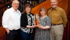 Cecil Hughson (left) and Gussie Angus (right) present competition organisers Vaila Grant and Valerie Watt with the new Catgut and Ivory trophy.