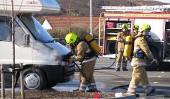 Firefighters using breathing apparatus and one hose reel jet to extinguish the fire in the engine compartment - Photo: Garry Sandison