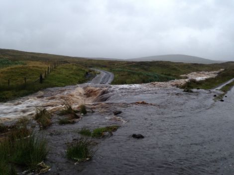 The Burn of Laxdale has burst its bank flooding the A970 at the north end of Cunningsburgh - Photo: Gary Keith