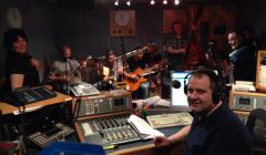 John Johnston in the chair at the end of a long night, with fellow broadcaster Jane Moncrieff (left) and a whole bunch of musicians from Hom Bru and The Revellers.