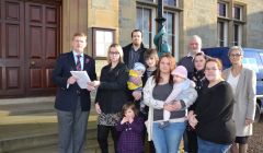 Council convener Malcolm Bell receives the 200-strong petition from Urafirth parents. Photo: Shetnews/Neil Riddell