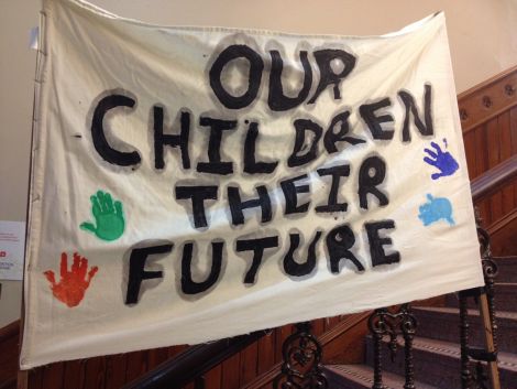 Protesters hung a banner on the stairs of Lerwick Town Hall on Wednesday morning. Photo: Shetnews