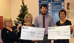 Toby Sandison of Scalloway Boating Club presenting cheques to Mind Your Head and the Shetland branch of Alzheimer Scotland.