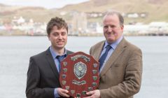 Fish farm worker Shaun McAlister receives his award from SSPO Shetland general manager Davie Sandison.