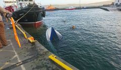 The overturned boat shortly before being lifted from the harbour - Photo: Caroline Watt/Shetland News