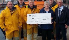 Lerwick lifeboat coxswain Alan Tarby (centre) accepts the donation from Alan and Sunniva Leask. Looking on are from left to right crew members Ian Harms, Grant Masson and John Best. Photo: RNLI