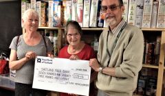 Christine Henderson and Helen Burgess donate a cheque to foodbank manager David Grieve.