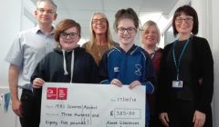 Katie Anderson and Aimee Laurenson handing over a cheque to NHS staff.