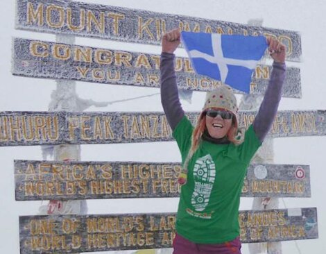 Anita Georgeson unfurling the Shetland flag at top of Africa.