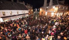 A crowd of people gathered on a street at night.