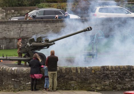 A group of people looking at a machine gun.