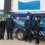 Four people standing next to a Scottish & Southern Electricity Networks utility vehicle. The vehicle is parked outside a building, and all individuals are dressed in work uniforms.