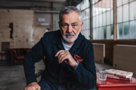 A man with a beard sitting on a red chair.