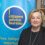 Woman standing in front of a citizens advice bureau banner.