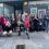 A group of people posing in front of a store.