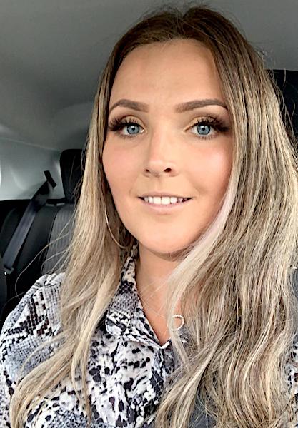 A woman sitting in the back seat of a car.