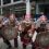 Three vikings dressed in armor walking down the street.