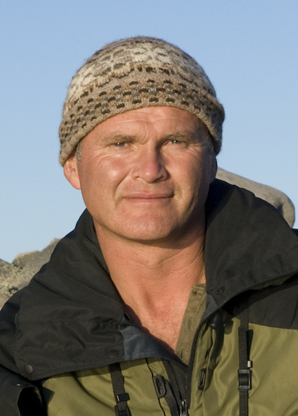 A man wearing a green jacket and hat.