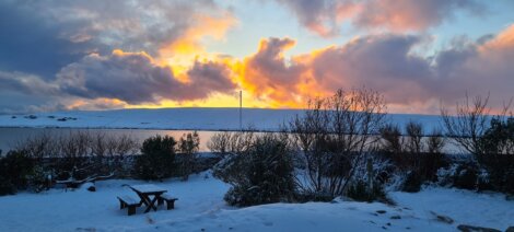 A sunset over a snow covered lake.