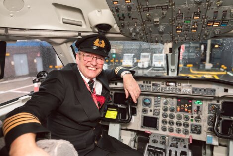 A pilot sitting in the cockpit of an airplane.