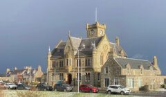 A large building with cars parked in front of it.