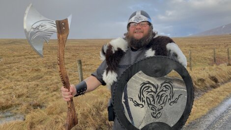 A man dressed as a viking holding an axe.