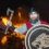 A man in a viking costume standing in front of a fire.