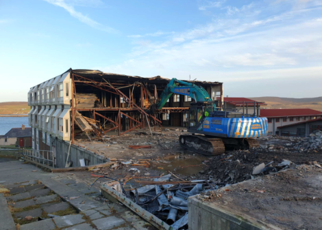 A building is being demolished by a bulldozer.