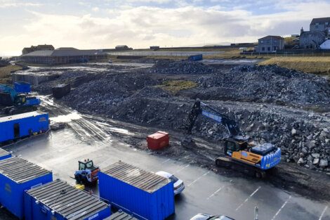 An aerial view of a construction site with blue containers.
