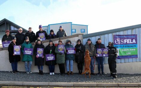 A group of people holding signs in front of a building.