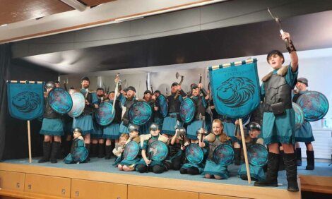 A group of children posing for a photo with shields.