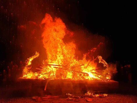 A bonfire on a dark night with flames.