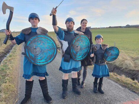 A group of people dressed as vikings on a road.