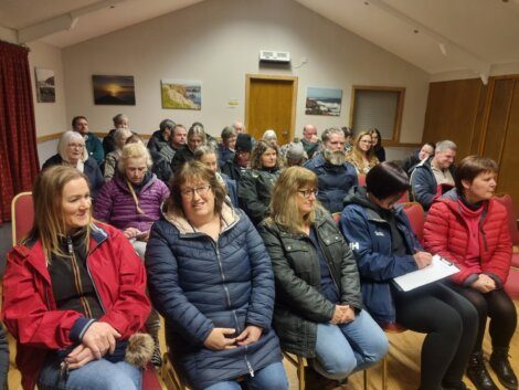 A large group of people sitting in a room.