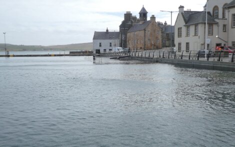 Quaint waterfront buildings beside a calm harbor.