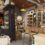 Interior of a cozy, rustic boutique store with shelves stocked with various items, including bottles and jars, under warm lighting.