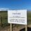 Sign at the SaxaVord UK Space Port reading: "Welcome to the SaxaVord Spaceport - Europe's first licensed vertical launch facility opened on 29 May 2024," against a backdrop of grass and clear sky.
