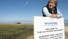 A person leans on a sign at SaxaVord UK Spaceport, which announces it as Europe's first licensed vertical launch facility, opened on May 29, 2024.