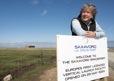 A person leans on a sign at SaxaVord UK Spaceport, which announces it as Europe's first licensed vertical launch facility, opened on May 29, 2024.
