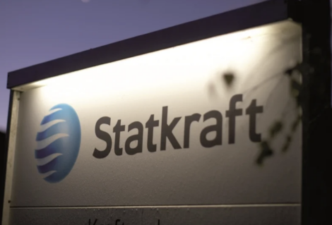 A sign for Statkraft featuring its logo, illuminated against a dark background.