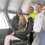 Four people onboard a boat's bridge, smiling at the camera. One person is seated while the others stand behind. The background shows the interior of the bridge with large windows.