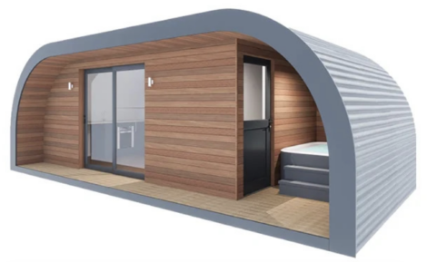 A modern, curved tiny house with wood paneling, sliding glass doors, and a small set of steps leading to an entrance. The interior is partially visible.