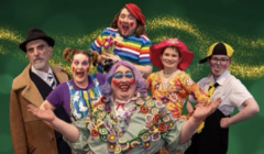 A group of six people dressed in colorful clown costumes, posing cheerfully against a green background with a golden swirl.