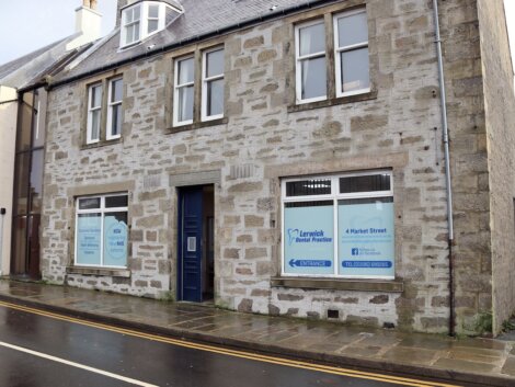 Street view of a stone building with windows displaying signage for "Lerwick Dental Practice" located at 4 Market Street.