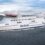 A large ferry named NorthLink sails on the water with mountains in the background.