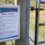 Sign on a wooden gate warns about bird flu affecting birds in Scotland, advising not to touch sick or dead birds and to keep dogs on leads.